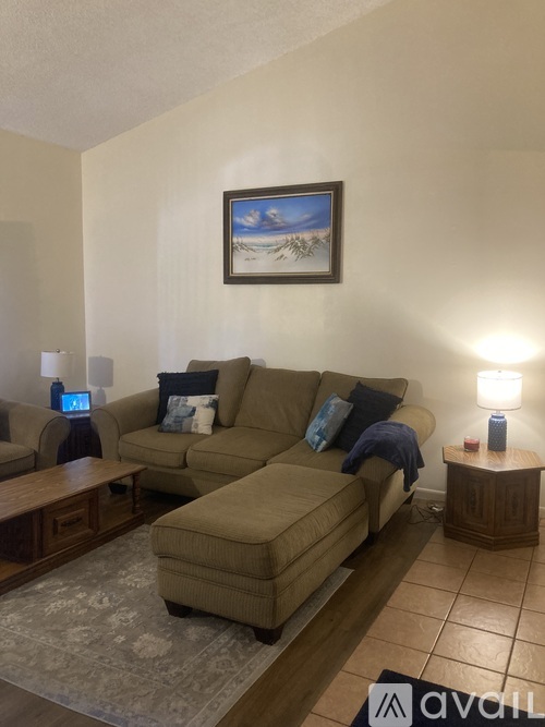 A living room with a couch, two chairs, and a coffee table.