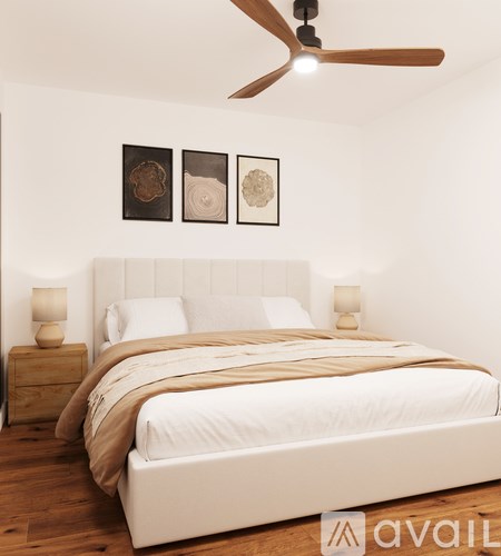 A bedroom with a large bed and a ceiling fan.