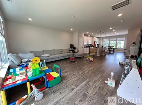 A living room with a sofa, a coffee table, and a child's toy car.
