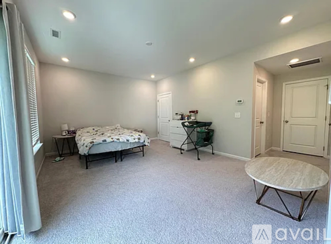A bedroom with a bed, chair, and table.