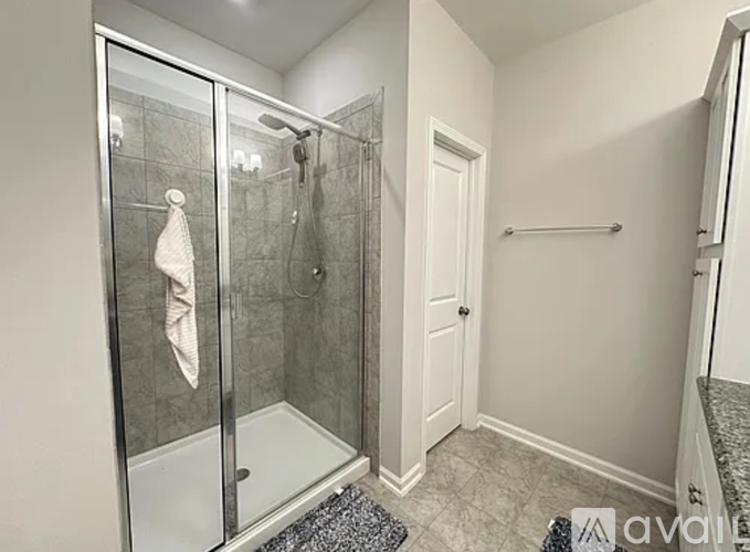A bathroom with a glass shower stall and a white door.