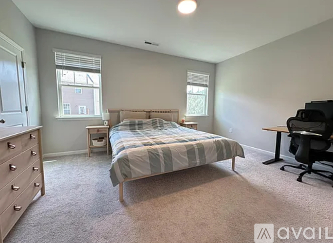A bedroom with a bed, desk, and chair.