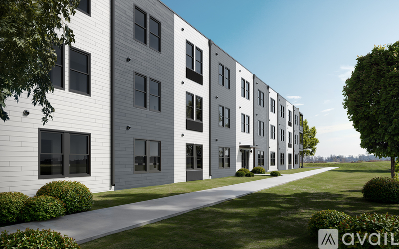 A line of modern townhouses with a grassy area in front.