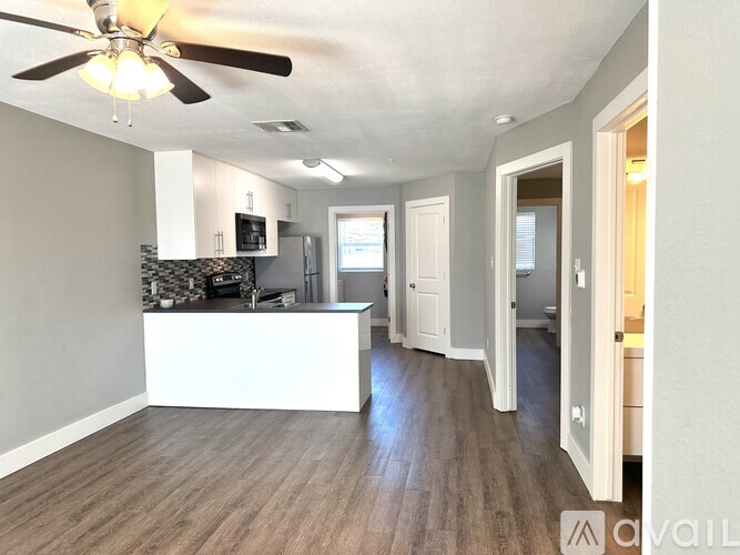 A spacious kitchen with a white island and a ceiling fan.