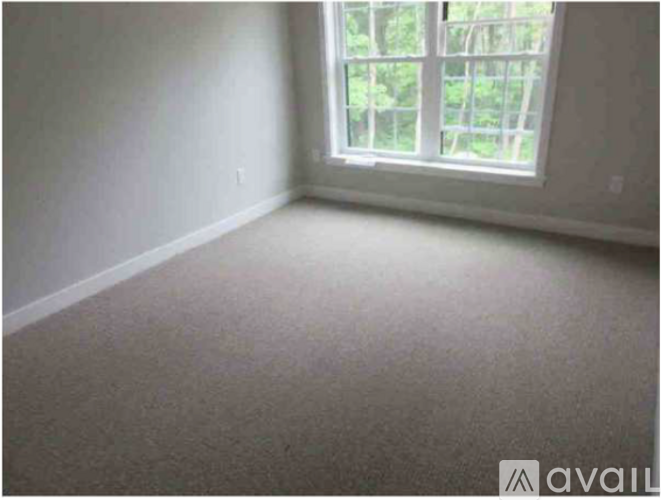 A room with a window and carpeted floor.