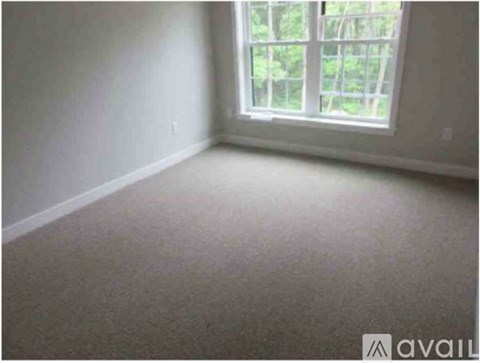 A room with a window and carpeted floor.