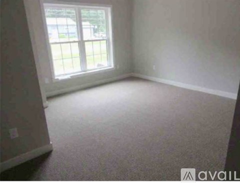 A room with a carpeted floor and a window.