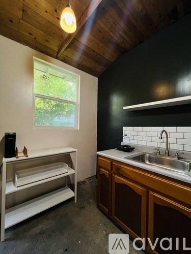 A kitchen with a wooden ceiling and a window.