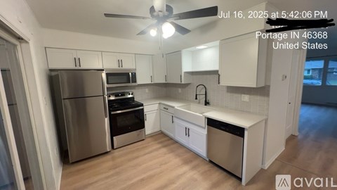 A kitchen with stainless steel appliances and white cabinets is available for rent.