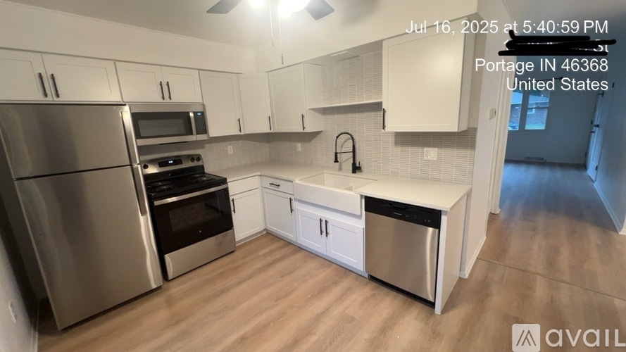 A kitchen with stainless steel appliances and white cabinets.