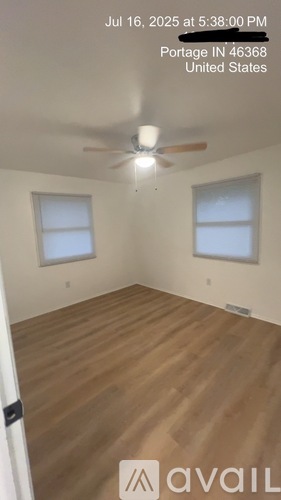 A room with wooden flooring and a ceiling fan.