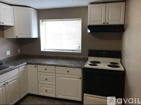 A kitchen with white cabinets and a black stove top oven.