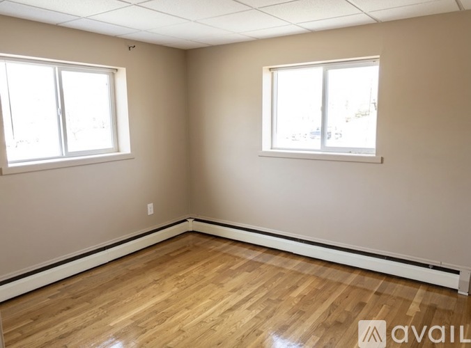 A room with wooden floors and two doors, one of which is open.
