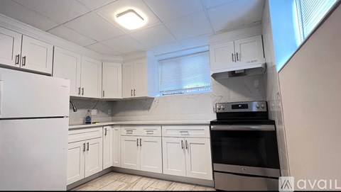 A kitchen with white cabinets and appliances.