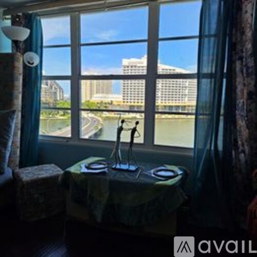 A room with a view of a river and buildings outside the window.