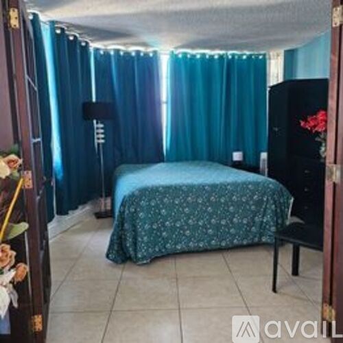 A bedroom with a bed and a dresser with a mirror.