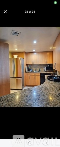 A kitchen with wooden cabinets and a granite countertop.