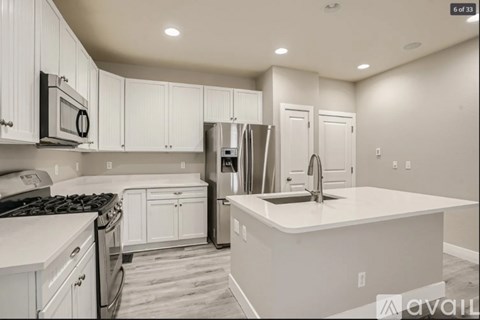A kitchen with white cabinets and appliances.