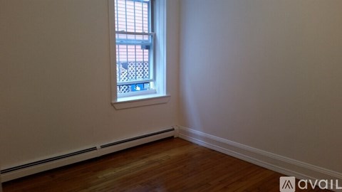 A room with a window and wooden floors.