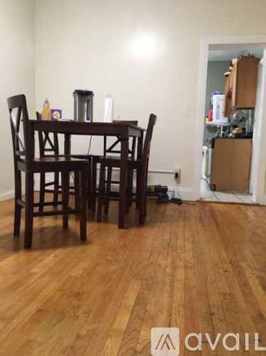 A brown wooden dining table with four chairs.