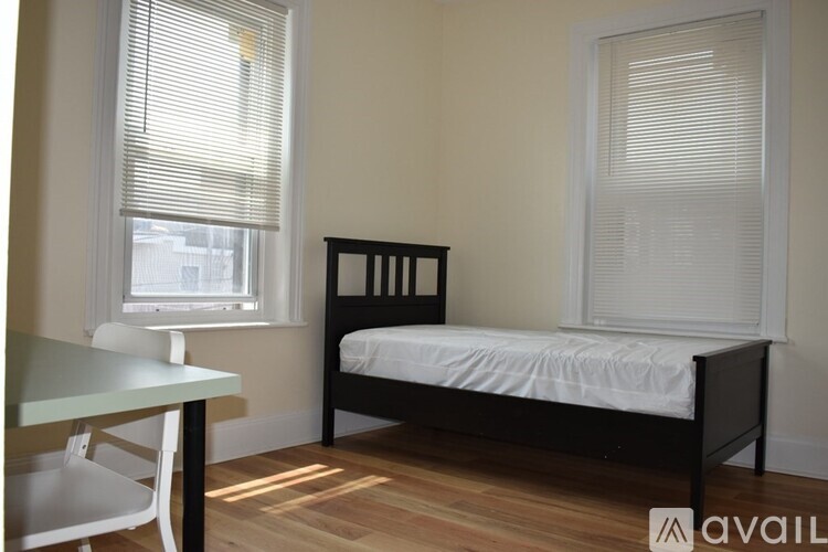 A bedroom with a bed, table and chairs.