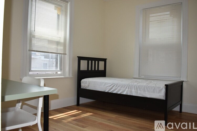 A bedroom with a bed, table and chairs.