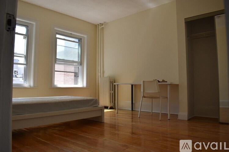 A room with a bed, desk, and chair.