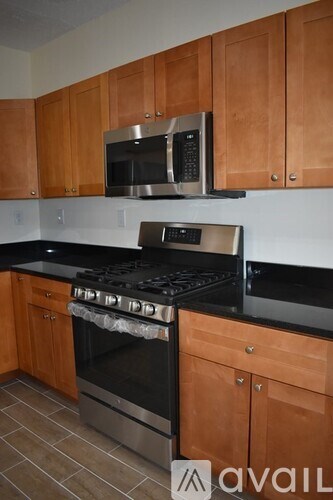 A kitchen with wooden cabinets and a black stove top.