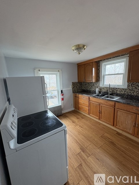 A kitchen with wooden cabinets and a white dishwasher.