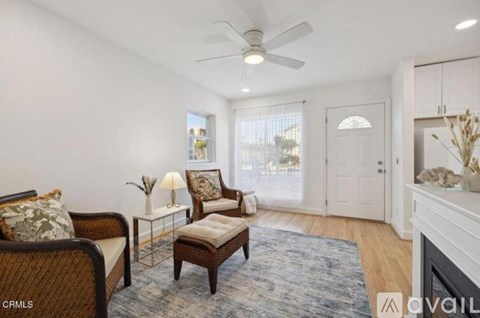 A living room with a brown chair and a white sofa.