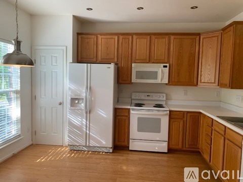 A kitchen with wooden cabinets and white appliances.