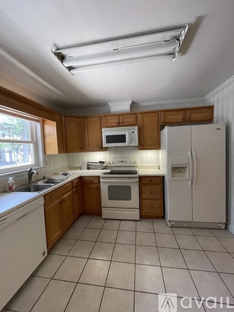 A kitchen with wooden cabinets and white appliances.