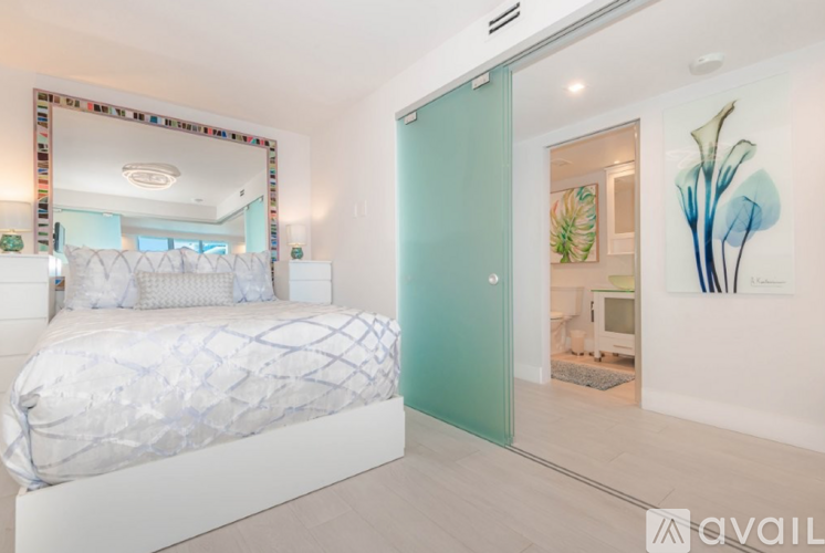 A bedroom with a large bed and a mirror on the wall.