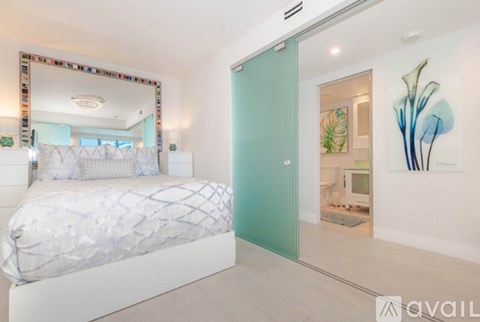 A bedroom with a large bed and a mirror on the wall.