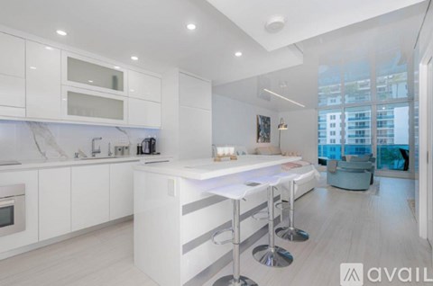 A modern kitchen with white cabinets and a marble countertop.