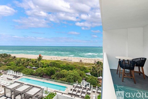 A view of a pool and beach from a balcony.