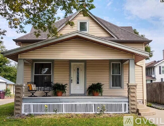 A small house with a porch and a white door.