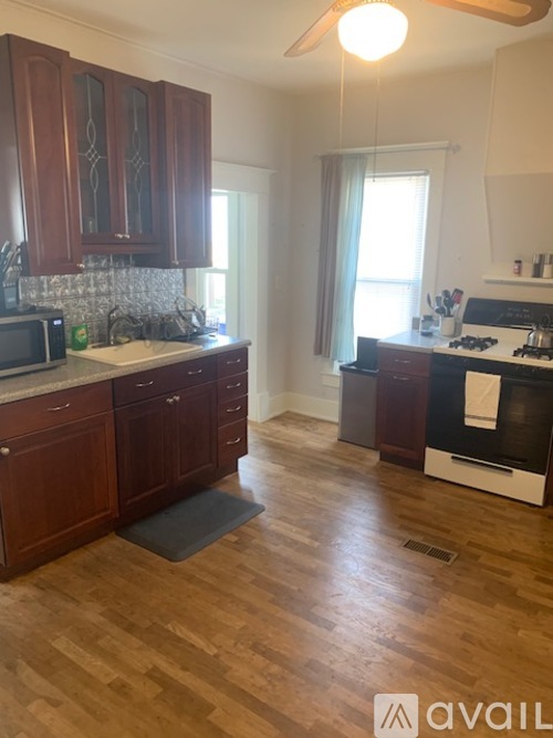 A kitchen with wooden cabinets and a black stove top oven.