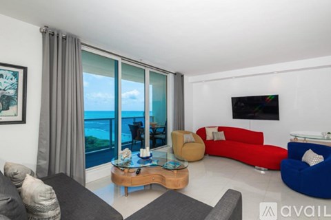 A living room with a view of the ocean through large windows.