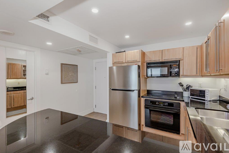 A modern kitchen with wooden cabinets and stainless steel appliances.