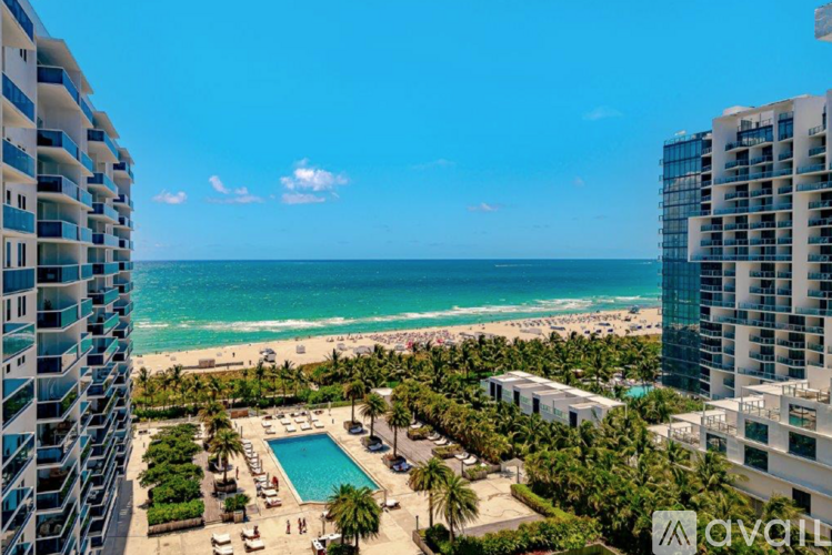 A view of a pool and beach from a high-rise building.