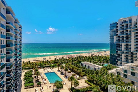 A view of a pool and beach from a high-rise building.