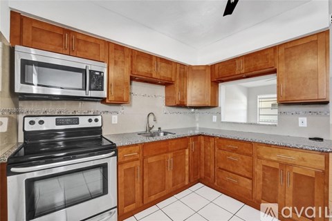 A kitchen with wooden cabinets and a black stove top oven.
