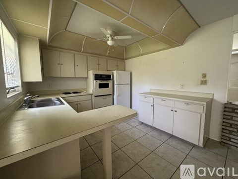 A kitchen with white cabinets and a tiled floor.