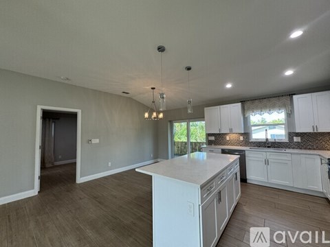 A spacious kitchen with white cabinets and a large island.