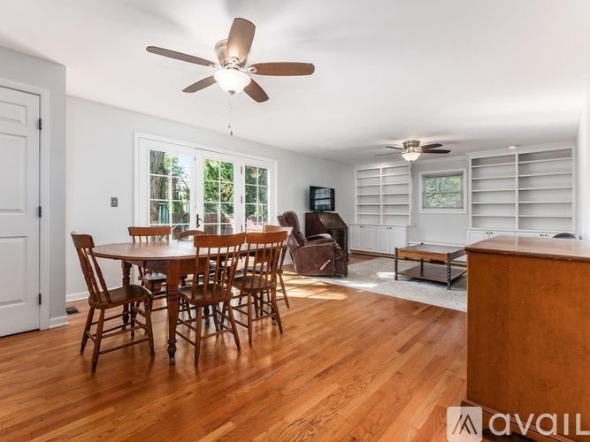 A dining room with a wooden table and chairs.