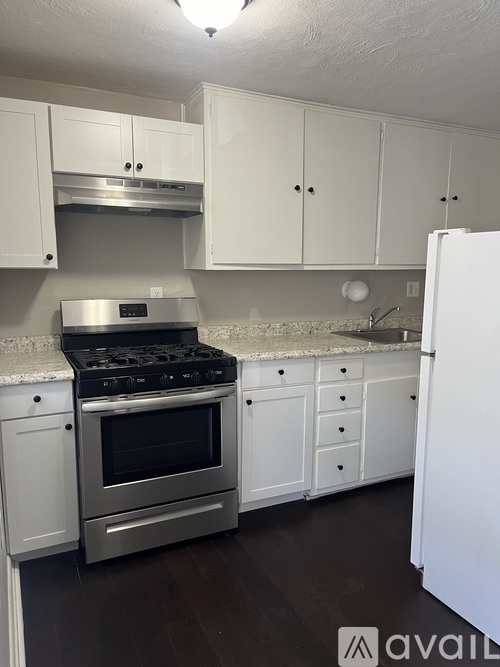 A kitchen with white cabinets and a stainless steel stove.