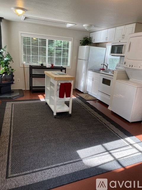 A kitchen with white appliances and a black stove top oven.