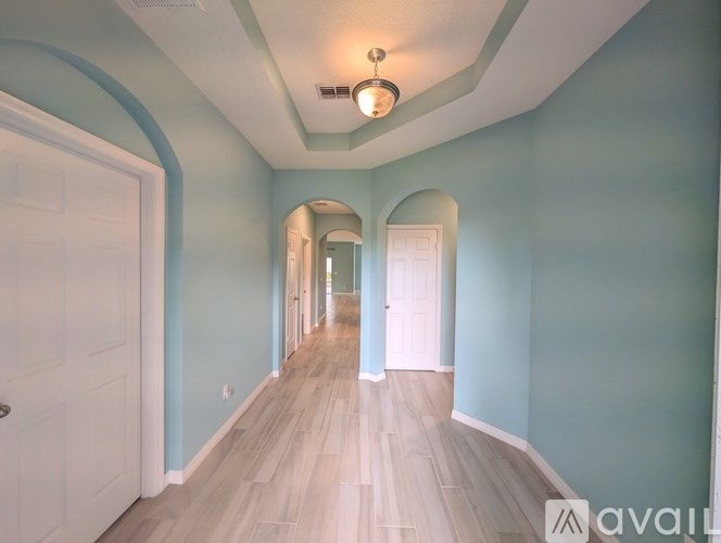 A long hallway with arched doorways and a light on the ceiling.