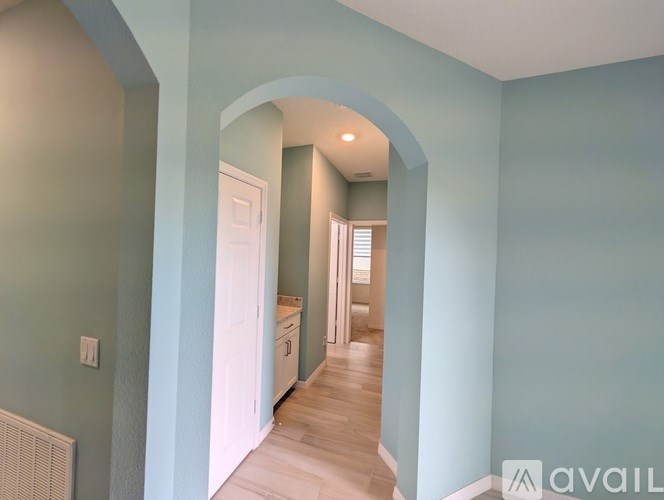 A hallway with a white door and a light switch on the wall.